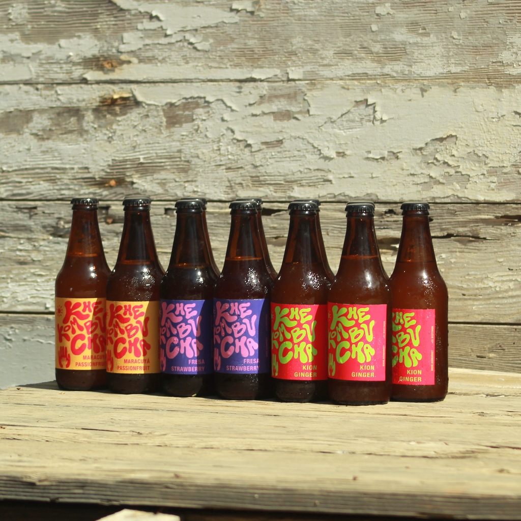 Pack de 12 kombuchas Khe en botellas de vidrio ámbar, bebidas fermentadas artesanales con cultivos vivos y sabores naturales.